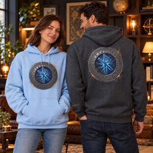 May include: A light blue hooded sweatshirt and a dark gray hooded sweatshirt, both featuring a circular emblem on the chest and back respectively. The emblem displays a glowing blue rune symbol surrounded by a metallic, engraved border.