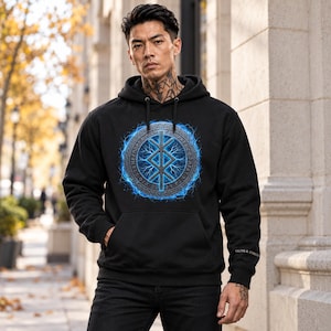 May include: A black hooded sweatshirt featuring a central circular graphic with a blue lightning effect surrounding a runic symbol. The text "SIGNS & SYMBOLS" is printed in white on the left sleeve cuff, and the garment has a front pocket.