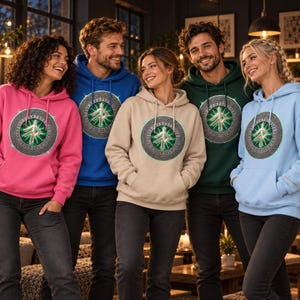 May include: A collection of five hooded sweatshirts in pink, blue, beige, dark green, and light blue. Each hoodie features a central circular graphic with a glowing green rune symbol surrounded by a detailed, metallic-textured Celtic knot border.