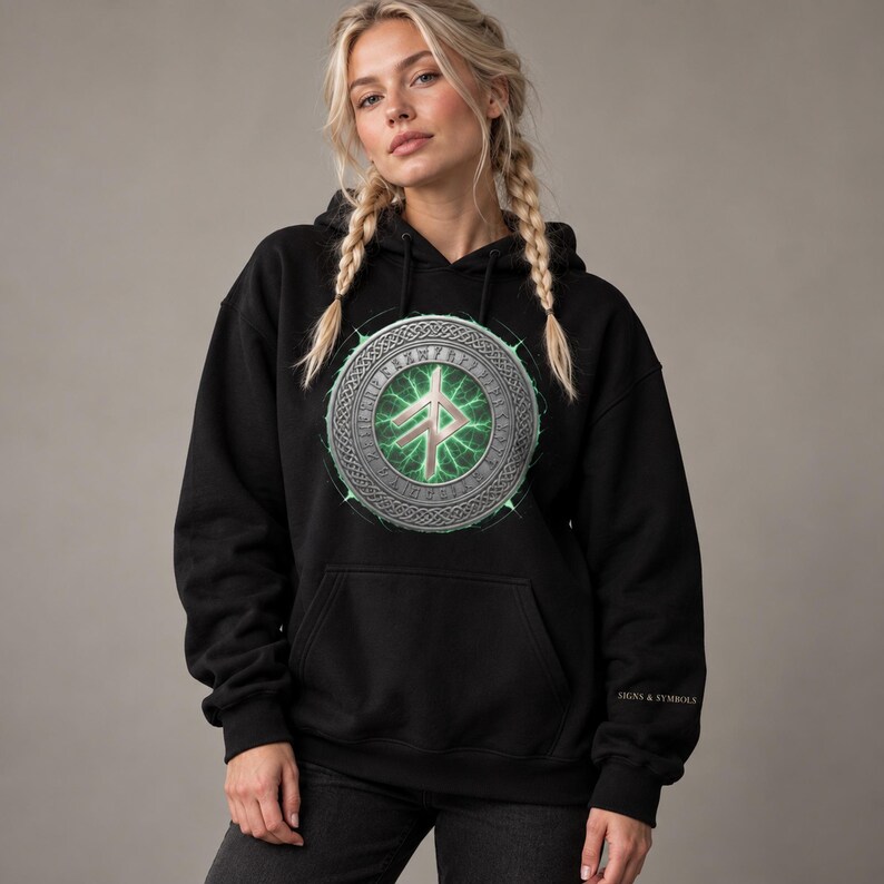 May include: A black hooded sweatshirt featuring a large circular graphic on the chest. The design displays a metallic silver runic symbol centered over a glowing green energy pattern, surrounded by an intricate border. The text SIGNS & SYMBOLS is printed on the sleeve.