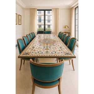 Puede incluir: Una mesa de comedor rectangular larga con una superficie de mosaico floral y geométrico detallada en tonos azul, naranja y crema, rodeada por doce sillas tapizadas en tela color verde azulado con marcos de madera clara en un entorno formal.