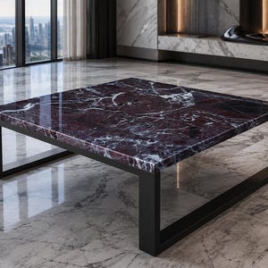 May include: A square coffee table featuring a polished deep burgundy marble top with prominent white veining. The table is supported by a sturdy, matte black metal frame with a continuous rectangular base design that provides structural stability.