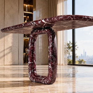 May include: A console table crafted from deep burgundy marble with prominent white veining. The piece features a smooth, elongated oval tabletop supported by a single, thick, rectangular base with rounded corners, showcasing a polished finish.