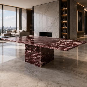 Puede incluir: Una gran mesa de comedor rectangular con una superficie de mármol rojo intenso pulido con vetas blancas prominentes. La mesa se apoya sobre una base de pedestal única, gruesa y cuadrada, fabricada con el mismo mármol rojo a juego.