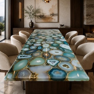 May include: A rectangular dining table featuring a surface composed of numerous polished, multi-colored agate slices in shades of teal, blue, white, and grey, set within a resin base, surrounded by six upholstered, curved-back dining chairs.