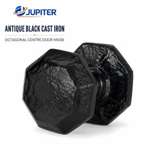 May include: An antique black cast iron octagonal center door knob with a textured, rugged surface. The product is labeled with the text JUPITER, ANTIQUE BLACK CAST IRON, and OCTAGONAL CENTRE DOOR KNOB. The knob features a distinct eight-sided shape.