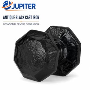 May include: An antique black cast iron octagonal centre door knob with a textured, rugged surface finish. The product is labelled with the text JUPITER, ANTIQUE BLACK CAST IRON, and OCTAGONAL CENTRE DOOR KNOB. The knob features a geometric shape.