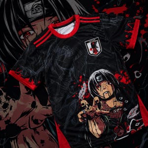 May include: A black short-sleeved jersey with red trim on the collar and sleeves. The shirt features a graphic of an anime character with dark hair and red eyes, a Japan Football Association crest, and a large, faint character print in the background.