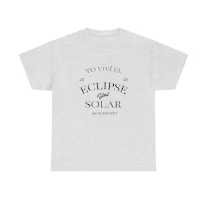 Puede incluir: Una camiseta de manga corta de color gris claro con el texto negro YO VIVÍ EL 20 26 ECLIPSE Total SOLAR del 18 AGOSTO centrado en el pecho. La prenda tiene un cuello redondo y un corte estándar con una textura de tela jaspeada.