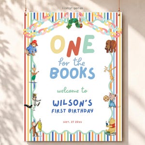May include: A rectangular poster with a vertical striped border featuring illustrations of storybook characters. The text reads: ONE for the BOOKS, welcome to WILSON'S FIRST BIRTHDAY, SEPT. 27 20XX. The design includes a caterpillar, bear, and other figures.