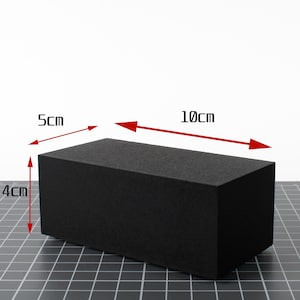 May include: A solid black rectangular foam block with a textured surface. Red arrows indicate dimensions of 10 inches in length, 5 inches in width, and 4 inches in height, providing a clear visual representation of the object's physical size.