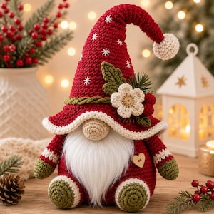 May include: A crocheted gnome figurine featuring a tall red pointed hat with white snowflake embroidery, a cream-coloured pom-pom, a long white beard, a round nose, green sleeves, and green feet. A cream flower and green leaves adorn the hat.
