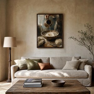 May include: A framed wall art print depicting a dark, painterly scene of water being poured from a brown ceramic pitcher into a wooden bowl filled with white flour, with a small lump of dough and a cloth resting on a wooden surface nearby.