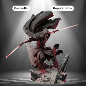 Peut inclure: Une figurine de personnage encapuchonné vêtu de sombre dans une pose dynamique, portant une armure et une cape flottante, maniant deux sabres laser rouges lumineux. Le personnage se tient sur une base rocheuse remplie de débris.