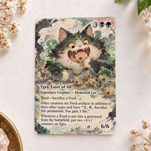 May include: A Magic: The Gathering trading card titled Ygra, Eater of All, featuring a large, fluffy, dark-furred cat with wide eyes eating a small, round, tan creature. The card text includes game rules, a 6/6 power and toughness, and mana costs.