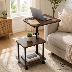May include: A two-tier mobile side table with a dark wood grain finish and black metal supports. The adjustable height top shelf holds a laptop, glasses, and a notebook, while the lower shelf holds a small potted succulent and stacked books.