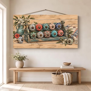 Puede incluir: Una pieza de arte mural rectangular de madera con la imagen impresa de un estante rústico que sostiene varios pomos de cerámica coloridos y estampados. El estante está rodeado de ilustraciones de hojas verdes, flores blancas y una jarra azul.