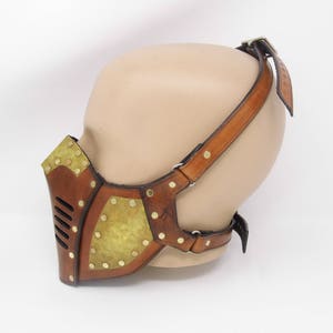 May include: A brown leather steampunk-style mask with brass accents and a strap that goes over the head.