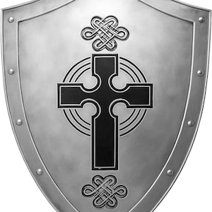 May include: A silver-coloured metal shield with a pointed base and a reinforced border featuring evenly spaced rivets. The centre displays a black Celtic cross design surrounded by concentric circles, with intricate knotwork motifs above and below.