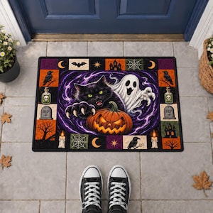 May include: A rectangular Halloween-themed doormat featuring a central illustration of a black cat and a ghost behind a jack-o'-lantern. The border contains small squares with images of ravens, tombstones, candles, bats, and spiderwebs.
