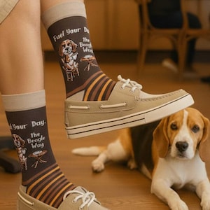 Könnte beinhalten: Braune Crew-Socken mit einer Grafik eines Beagles, der an einem Tisch sitzt, und dem Text Fuel Your Day. The Beagle Way. Die Socken haben ein beiges Bündchen und ein Streifenmuster in Braun-, Orange- und Beigetönen, kombiniert mit beigen Bootsschuhen.
