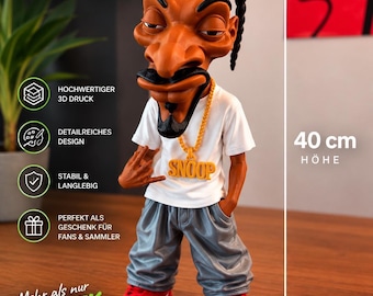 May include: A 3D printed caricature figurine of a person with braided hair, wearing a white t-shirt, gray baggy pants, and red sneakers. The figure features a gold-colored chain with a pendant reading SNOOP. A vertical arrow indicates a height of 40 cm.