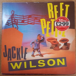 Peut inclure: Pochette de l'album du single "Reet Petite" de Jackie Wilson. L'illustration présente une figurine en pâte à modeler saluant, avec des formes géométriques orange et bleues. Le titre est en grandes lettres jaunes, avec une étiquette de prix.