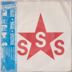 May include: A red star with a white "S" in the centre and two white "S"s on the points of the star. The text "SIGUE SIGUE SPUTNIK" is printed in blue on a white background with a list of the band's interests.