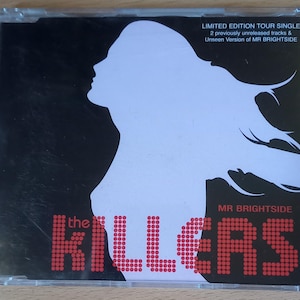 May include: A black and white CD single with a silhouette of a woman's head and shoulders with long hair. The text "the KILLERS" is in red and the text "MR BRIGHTSIDE" is in white. The text "LIMITED EDITION TOUR SINGLE" is in black and white. The text "2 previously unreleased tracks & Unseen Version of MR BRIGHTSIDE" is in black and white.