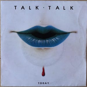 Pode incluir: Uma capa de disco de vinil quadrada com o texto TALK TALK no topo e TODAY na parte inferior. O centro exibe um par de lábios azuis sobre um fundo branco, com uma única gota vermelha caindo do lábio inferior em direção à borda inferior.