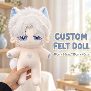 Puede incluir: Una muñeca de peluche con cabello de piel sintética blanca, orejas y ojos azules. La muñeca tiene un tono de piel claro, un bordado de copo de nieve en el pecho y huellas de patas azules en las manos. Texto: CUSTOM FELT DOLL 10cm / 20cm / 30cm / 40cm.