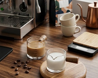 Tazzina da espresso in vetro borosilicato con manico in noce e caraffa graduata da 75 ml.