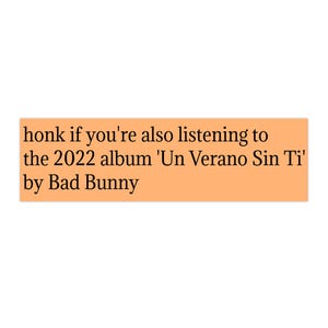 Op de afbeelding: Een rechthoekige perzikkleurige sticker met zwarte tekst die luidt: honk if you're also listening to the 2022 album 'Un Verano Sin Ti' by Bad Bunny. Het ontwerp is eenvoudig, met de tekst gecentreerd op de effen lichtoranje achtergrond.