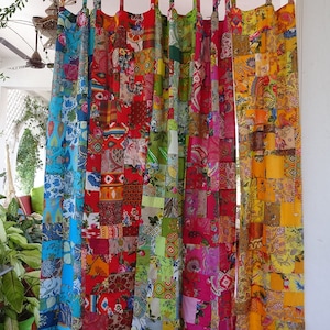 Peut inclure: Un ensemble de rideaux en patchwork colorés, faits de différents tissus. Les rideaux sont suspendus à une tringle et sont composés de carrés de différentes couleurs et motifs. Les rideaux sont un mélange de couleurs vives, notamment le rouge, l'orange, le jaune, le vert, le bleu et le violet.