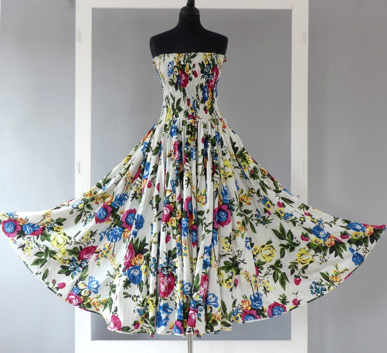 Mid-length strapless dress with smocked bodice on a 35-panel skirt in white cotton flower print with matching scarf