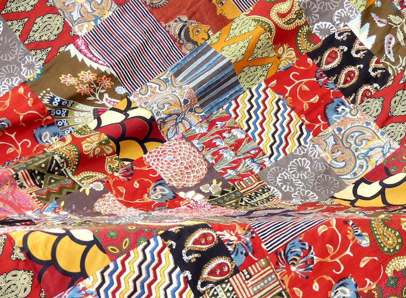 Peut inclure: Une courtepointe patchwork color&eacute;e avec une vari&eacute;t&eacute; de motifs et de couleurs, notamment le rouge, le bleu, le vert, le jaune et le noir.