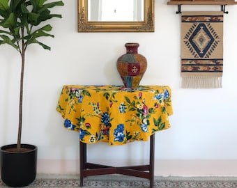 Liten rund gul duk, 110 cm i diameter, tillverkad av gul bomull med stora blommönster, lämplig för ett piedestalbord eller runt bord