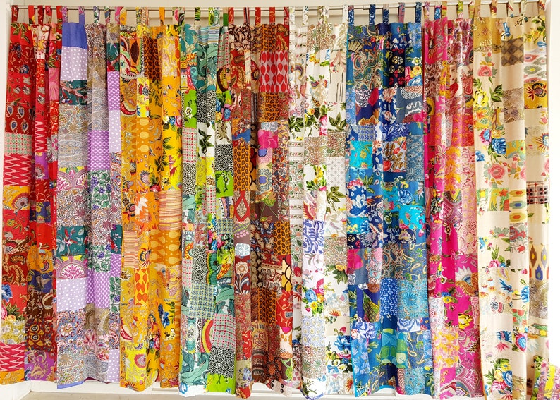May include: A set of colorful patchwork curtains with a variety of floral and geometric patterns. The curtains are made from different fabrics and sewn together in a random pattern.