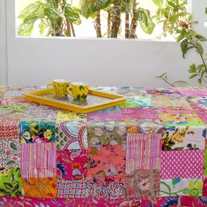 K&ouml;nnte beinhalten: Eine bunte Patchwork-Tischdecke mit einem gelben Tablett und zwei gelben Tassen darauf. Die Tischdecke besteht aus verschiedenen Stoffen mit floralen und geometrischen Mustern.