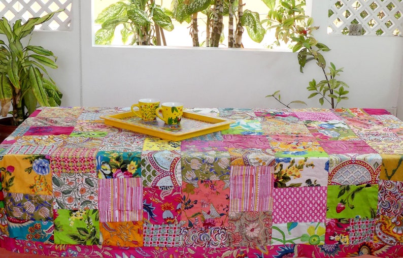 K&ouml;nnte beinhalten: Eine bunte Patchwork-Tischdecke mit einem gelben Tablett und zwei gelben Tassen darauf. Die Tischdecke besteht aus verschiedenen Stoffen mit floralen und geometrischen Mustern.