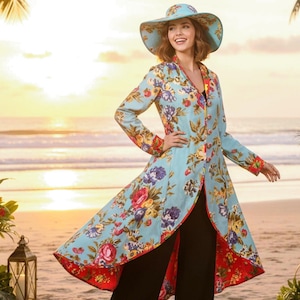 May include: A light blue floral print duster coat and matching wide-brimmed hat. The coat features a V-neck, long sleeves, and a flowing design with a red floral trim. The floral pattern includes red, purple, and yellow flowers.