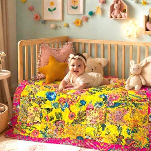 Peut inclure: Un bébé est allongé sur une couverture florale jaune vif dans un berceau en bois. La couverture présente un motif patchwork avec des motifs floraux roses, bleus et verts. Des oreillers décoratifs et des animaux en peluche entourent le bébé, créant un cadre de chambre d'enfant douillet.