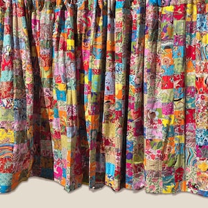 Può includere: Pannelli di tende patchwork colorati. Le tende sono realizzate con quadrati di tessuto in colori vivaci come rosso, arancione, giallo, blu e rosa. I quadrati di tessuto presentano motivi floreali e geometrici.