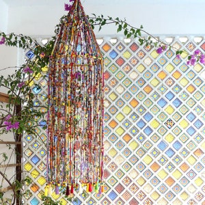Large round suspension in fabric link and wooden beads with small figurines and pompoms in finish