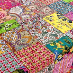 K&ouml;nnte beinhalten: Ein bunter Patchwork-Deckenbezug mit verschiedenen floralen und geometrischen Mustern in den Farben Rosa, Gr&uuml;n, Gelb, Blau und Rot.