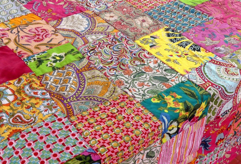 K&ouml;nnte beinhalten: Ein bunter Patchwork-Deckenbezug mit verschiedenen floralen und geometrischen Mustern in den Farben Rosa, Gr&uuml;n, Gelb, Blau und Rot.