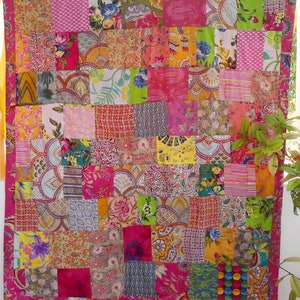 K&ouml;nnte beinhalten: Ein Patchwork-Deckenbezug mit einer Vielzahl von bunten Stoffen und Mustern. Die Decke besteht aus Quadraten und Rechtecken in verschiedenen Gr&ouml;&szlig;en und Farben, darunter Pink, Gelb, Gr&uuml;n, Blau und Rot. Die Decke ist ein lebendiges und vielseitiges St&uuml;ck Textilkunst.