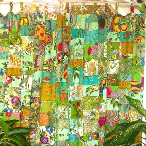 May include: A pair of green and turquoise patchwork curtains with a floral and geometric pattern. The curtains are made of different fabrics sewn together in a grid pattern.