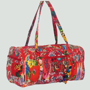Peut inclure: Un sac de voyage matelassé rouge à motif floral avec une fermeture à glissière et un pompon à perles. Le sac a deux poignées supérieures.