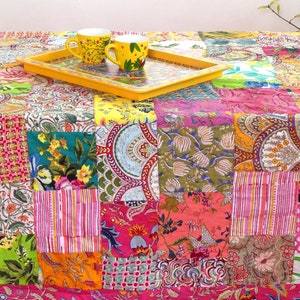 K&ouml;nnte beinhalten: Eine bunte Patchwork-Tischdecke mit einem gelben Tablett und zwei gelben Tassen darauf. Die Tischdecke besteht aus verschiedenen Stoffen mit floralen und geometrischen Mustern.